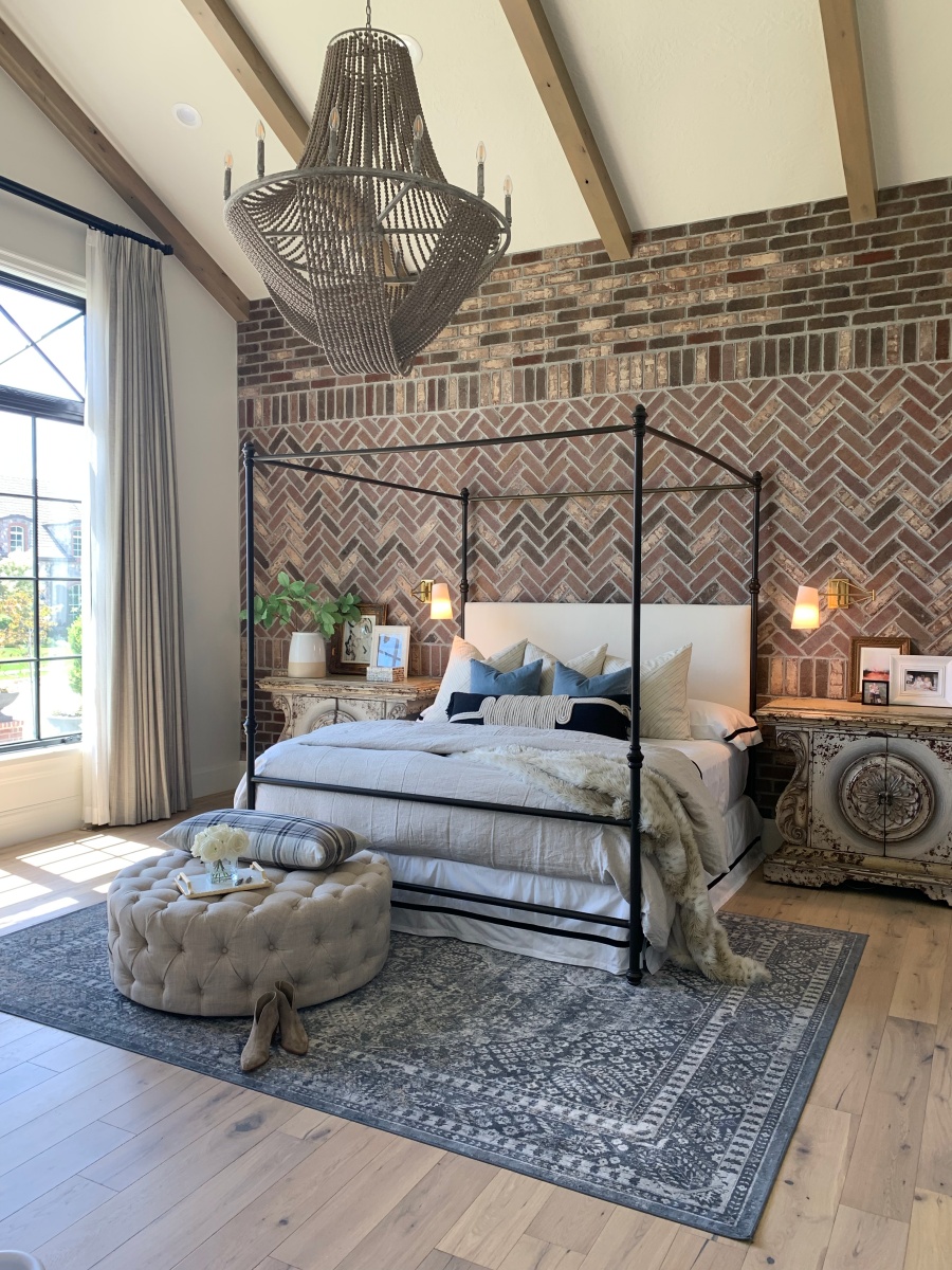 french country master bedroom with brick wall and blue accents